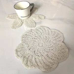 Detailed texture of a vintage cream white crochet lace flower coaster on a table