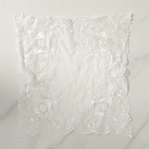 Close-up of the delicate floral embroidery on a vintage white lace placemat mesh