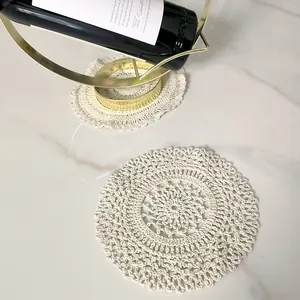 Close-up detail of a vintage round cotton lace coaster on a white marble surface
