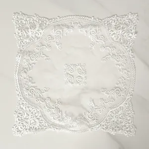 Detailed view of intricate white floral lace embroidery on sheer mesh fabric