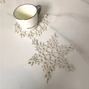 Detailed view of handmade crocheted cotton snowflake coaster on marble surface