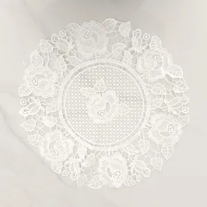 Exquisite detail of white rose embroidered water-soluble lace doily on marble surface