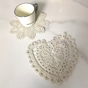 Macro view of vintage white lace coasters with heart and flower embroidery details