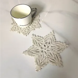 Detailed view of vintage snowflake-shaped lace crochet coasters on a marble tabletop