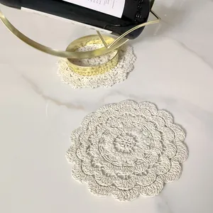 Close-up detail of a vintage white crochet lace coaster with hollow flower embroidery