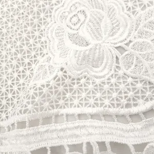 Close-up view of delicate white water-soluble lace fabric with rose embroidery patterns