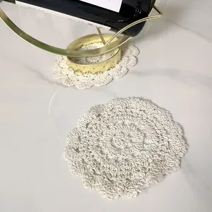 Close-up of vintage off-white hollow crochet lace coaster on marble table
