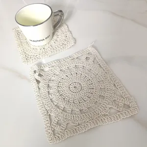Detailed macro view of cream square hollow crochet cotton coaster with white ceramic mug