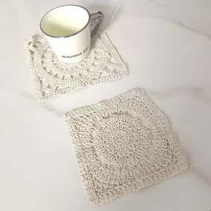 Detailed view of cream square crochet cotton lace coaster on marble surface