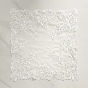 Detail view of white floral lace embroidery on sheer mesh fabric tablecloth