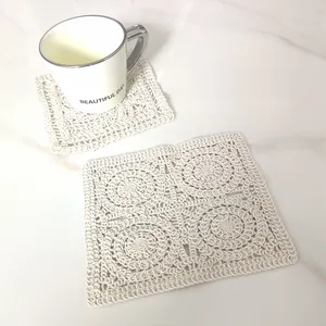 Close-up of vintage hand-crocheted cotton square coaster on a marble surface