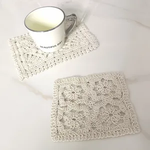 Detail view of cream retro hollow lace embroidered cotton square coaster on marble table