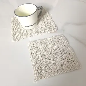 Detail view of retro beige lace crochet coasters on white marble