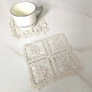 Detail view of a vintage cream lace hollow embroidered cotton square coaster