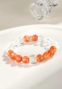 Nahaufnahme von natürlichem Rotgummi-Blumen- und Bergkristallarmband mit Würfelperle