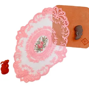 Nahaufnahme des rosa Spitzen-Platzsets mit Blumenstickerei und ovalem Wellenrand