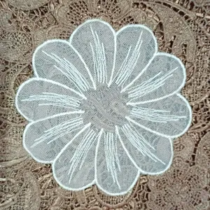 Close-up of a white embroidered flower applique with circular net base for DIY lace