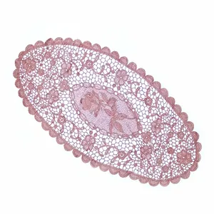 Makroansicht des rosa ovalen Spitzen-Platzdeckchens mit floraler Stickerei und Details