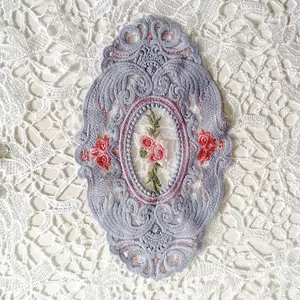 Detaillierte Nahaufnahme eines ovalen Vintage-Spitzenuntersetzers mit Blumenstickerei