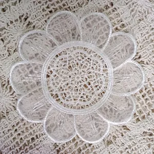 Detailed macro view of delicate white embroidered floral organza coaster for DIY crafts