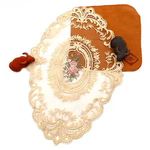 Hochwertiges Detail eines eleganten beige ovalen Spitzen-Platzsets mit Blumenstickerei-Detail