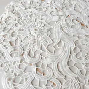 Close-up detail of white lace embroidered placemat showing intricate floral patterns