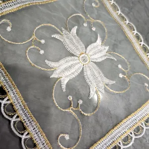 Close-up van een elegante vierkante mesh onderzetter met bloemen kant borduurwerk