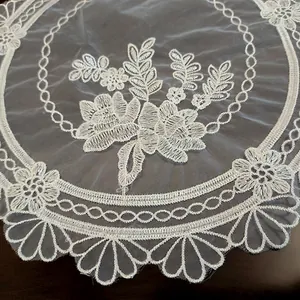 Detailed close-up of a white European lace doily with elegant floral embroidery