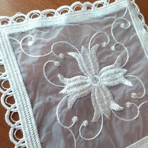 Macrodetail van een elegante vierkante witte kanten geborduurde onderzetter met bloemen