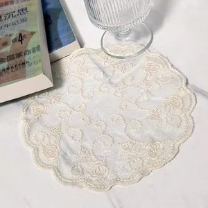 Detailed close-up of a vintage round lace coaster with intricate floral embroidery patterns