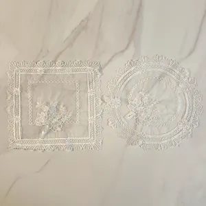 Detailed macro view of elegant white lace doilies with floral embroidery on marble