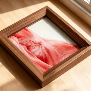 Detailed close-up view of 3D moving sand art with red glitter in a square wood-grain frame.
