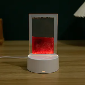 Detalle de la lámpara de arte de arena movediza 3D con líquido rojo y base blanca