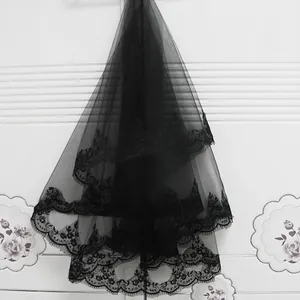 Detailaufnahme eines schwarzen, mehrlagigen Brautschleiers mit Eyelash-Spitzenstickerei.