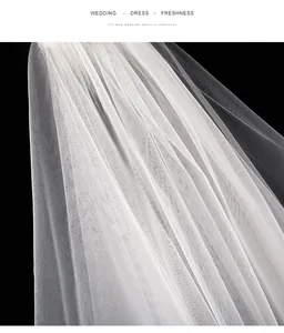 Primer plano detallado que muestra la suave textura del velo de novia de malla suiza blanca
