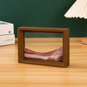 Detailansicht eines 3D-Fließsandbildes in einem braunen Holzrahmen auf einem Schreibtisch