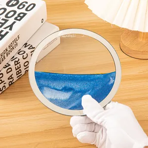 Primer plano de un adorno circular de arte de arena móvil 3D con arena fluida azul y dorada.