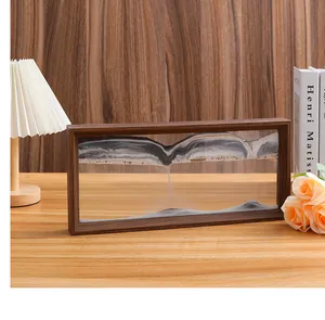 Primer plano de un cuadro de arena móvil rectangular sobre un escritorio de madera.