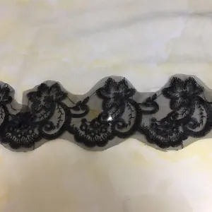 Detailansicht eines schwarzen doppellagigen Brautschleiers mit floraler Stickerei.
