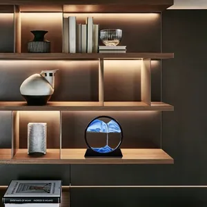 Creative 3D moving sand art decor with blue sand and black frame on a luxury shelf.