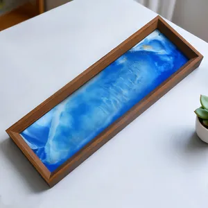 Primer plano de una bandeja rectangular de madera con arte fluido de resina marina.