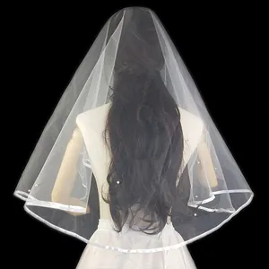 Primer plano de elegante velo de novia de una capa con perlas y borde de cinta.
