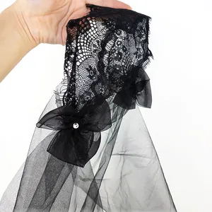 Gros plan détaillé d'un voile de mariée noir avec dentelle et strass.