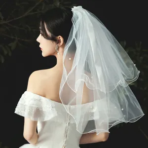 Elegant multi-layer short bridal veil with delicate pearl accents for a minimalist wedding