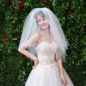 Vue détaillée d'un voile de mariée en maille blanche douce à plusieurs couches dans un jardin