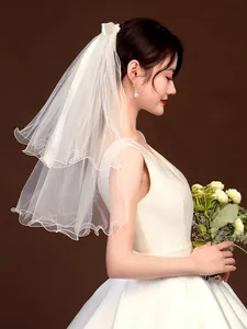 Elegant side view of a short tiered white bridal veil with delicate curly edges
