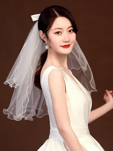 Side view detail of a simple white short bridal veil with elegant layered mesh on model