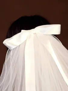Detailed close-up of a elegant white bridal veil featuring a large satin bow design
