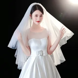 Close-up detail of a minimalist white bridal veil with a soft, ethereal forest style design.