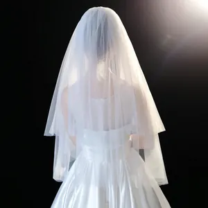 Back view of a short sheer white bridal veil with elegant layered design in soft light.